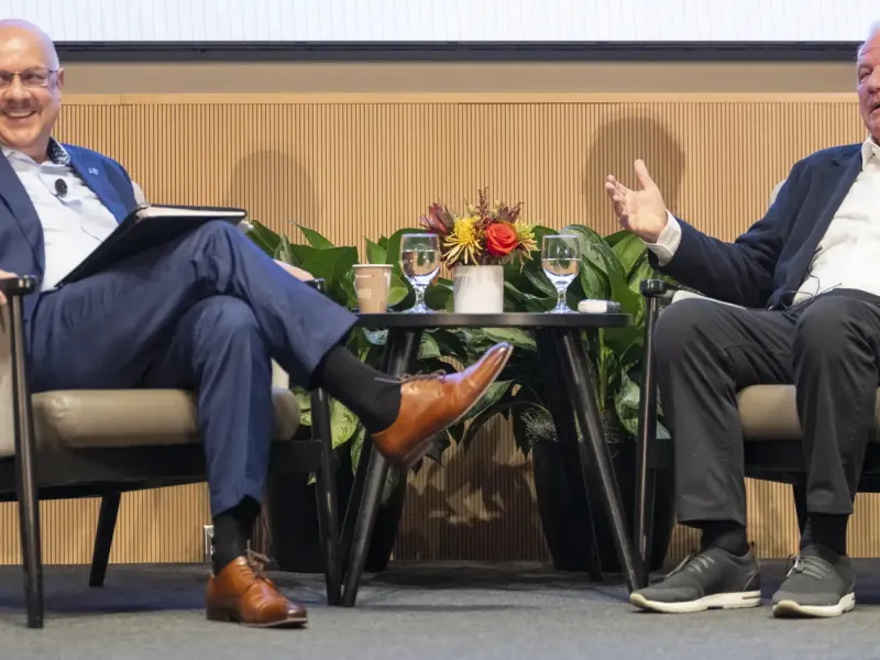 People sitting on stage during a panel discussion