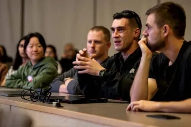 CMU students in the Privacy Engineering continuing education certificate program seated in a classroom with one student speaking