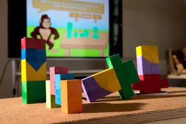 Children's blocks on a table with a game on the screen in the background
