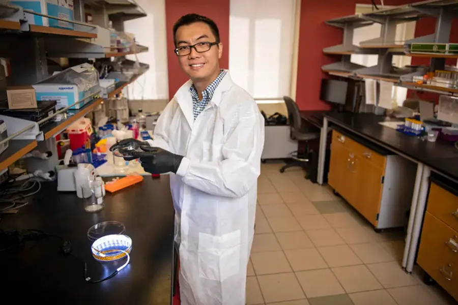 Leon Zhao wearing a white coat in a lab