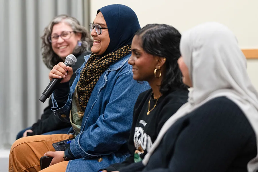 Audience members at an event, one using a microphone